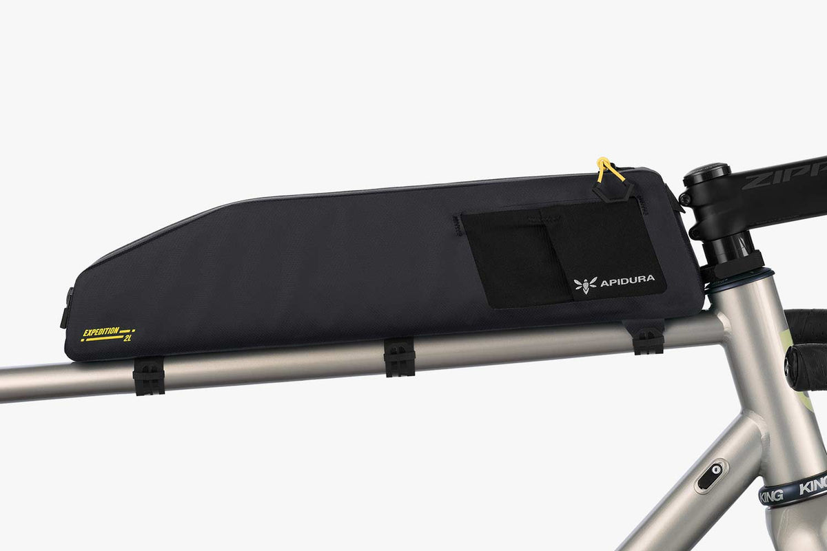 Apidura Expedition Long Top Tube Pack (2L) mounted on the top tube of a gravel bike, side view