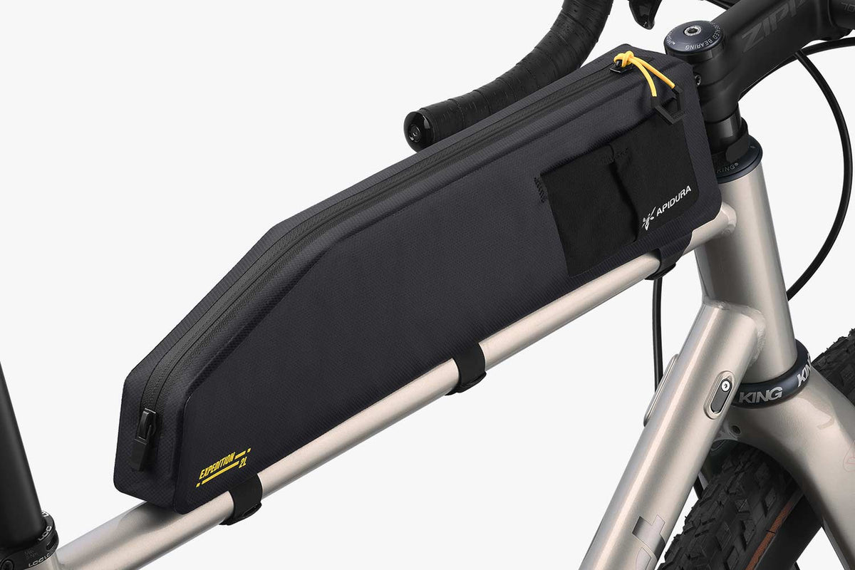 Apidura Expedition Long Top Tube Pack (2L) on a gravel bike, angled view of zip and stem strap